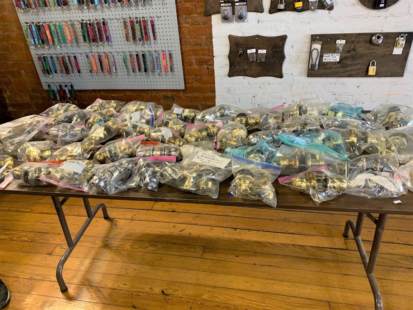 Inside Lee's shop: a wall of colorful key blanks and a table full of bagged door locks and hardware